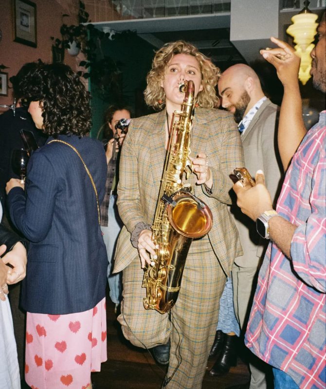 Alannah playing the saxophone at a party